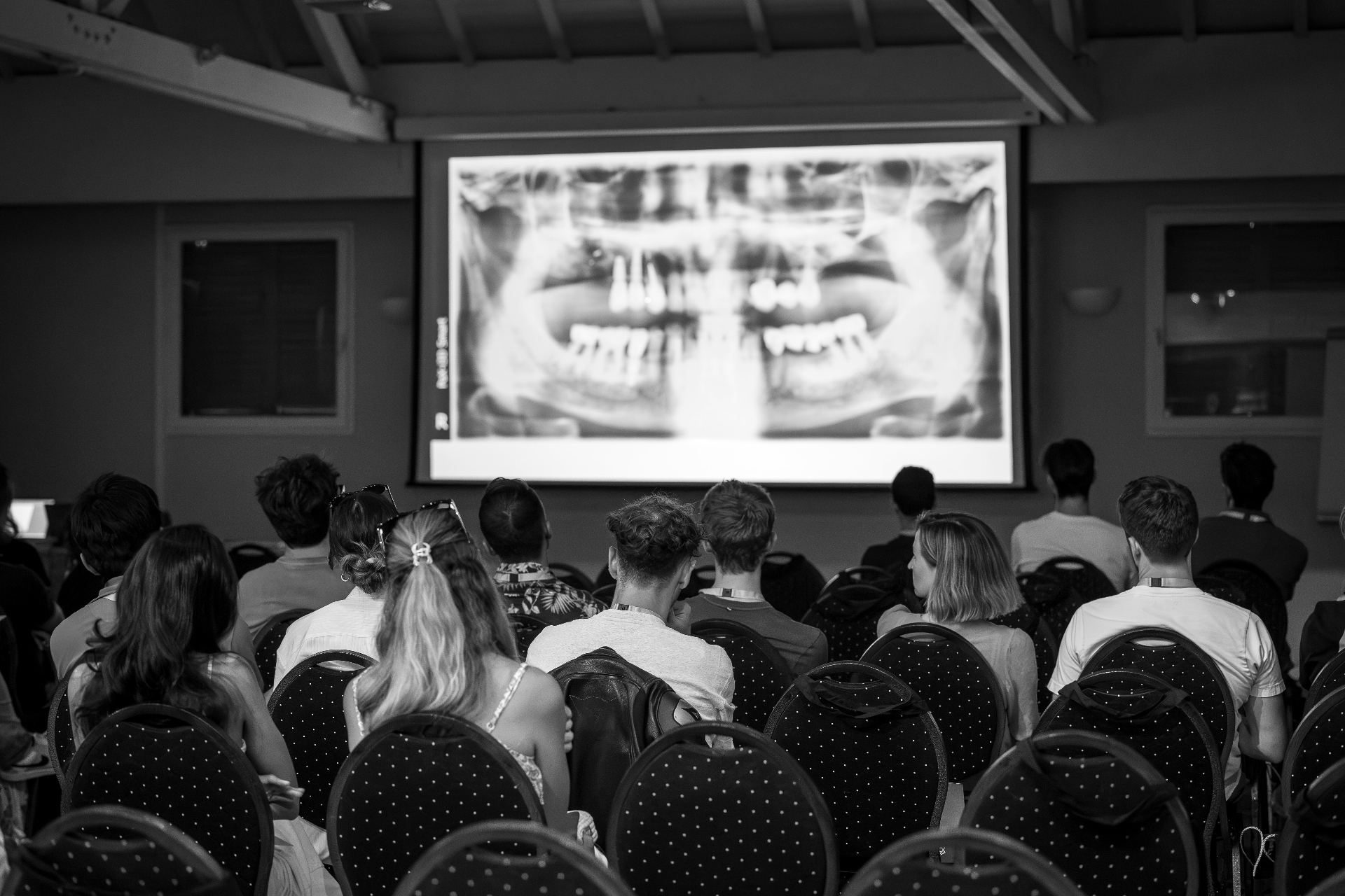 Conférence Smile Academy — auditoire de praticiens devant une radiographie panoramique