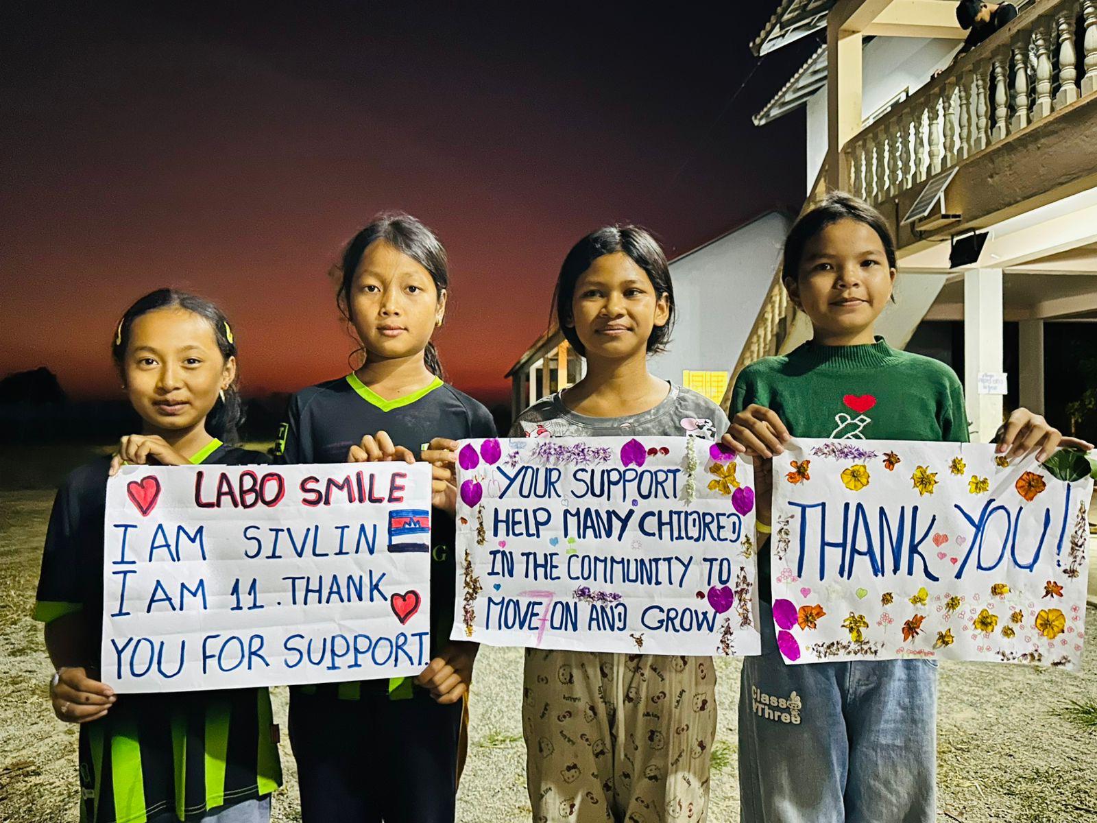 Quatre enfants tenant des pancartes de remerciement adressées à LaboSmile